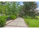 The Lake Concord Park trail is lined with green plants and flowers at 136 Triplet Lake Dr, Casselberry, FL 32707