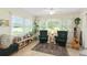 The sun room has many windows, plants, comfortable chairs, and is perfect for relaxation at 136 Triplet Lake Dr, Casselberry, FL 32707