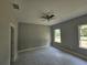 Freshly painted bedroom has modern ceiling fan, new windows, and sleek tile flooring awaiting final touches at 141 W G H Washington St, Apopka, FL 32703