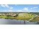 Aerial view showcases waterfront homes, docks, and sprinklers on a lush green golf course at 1467 Selbydon Way, Winter Garden, FL 34787
