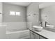 Bathroom featuring a vessel sink, soaking tub with tiled surround, and quartz countertop at 1467 Selbydon Way, Winter Garden, FL 34787