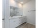 Bathroom boasts double sinks with white cabinetry, quartz counters, and modern fixtures at 164 14Th Ave, Longwood, FL 32750