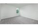 A bright bedroom featuring gray carpet, white walls, and a window providing natural light at 164 14Th Ave, Longwood, FL 32750