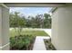 Front garden and walkway with green foliage viewed from under a covered home entryway at 164 14Th Ave, Longwood, FL 32750