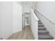 Inviting hallway with wood-look floors, leading to carpeted stairs and white walls at 164 14Th Ave, Longwood, FL 32750