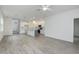 Open living room features light wood floors flowing into a kitchen with white cabinets and a gray island at 164 14Th Ave, Longwood, FL 32750