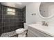 Bathroom with tiled walk-in shower, updated vanity and round mirror at 175 Cliff St, Deland, FL 32720