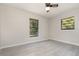 Bright bedroom features neutral walls, ceiling fan and two windows with a view at 175 Cliff St, Deland, FL 32720
