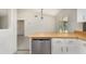Bright kitchen featuring white cabinets and wood countertops with stainless steel dishwasher at 175 Cliff St, Deland, FL 32720