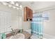 Bright bathroom features a vanity, built in cabinet, and a tub with a blue and white shower curtain at 1880 Lorraine Way, St Cloud, FL 34769