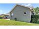 Side view of the home's exterior highlighting the green lawn and stucco siding at 1880 Lorraine Way, St Cloud, FL 34769