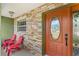 Cozy front porch with brick accents, seating and a decorative front door at 1880 Lorraine Way, St Cloud, FL 34769