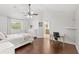 Bright main bedroom featuring wood floors, a ceiling fan, and an ensuite bathroom at 1880 Lorraine Way, St Cloud, FL 34769