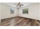 This bedroom is bright with two windows and has hardwood floors and a ceiling fan at 2040 E Triangle Dr, Longwood, FL 32779