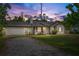 Charming single-Gathering home featuring a brick and white exterior, well-maintained lawn, and attached garage at 2040 E Triangle Dr, Longwood, FL 32779