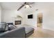 Bright living room features a decorative fireplace, ceiling fan, and a comfortable black leather couch at 2040 E Triangle Dr, Longwood, FL 32779