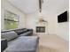 Bright living room features a decorative fireplace, ceiling fan, and a comfortable gray leather couch at 2040 E Triangle Dr, Longwood, FL 32779