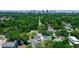 Stunning aerial view of lush neighborhood with mature trees and a modern home, city skyline in the distance at 21 N Hampton Ave # Lot 2, Orlando, FL 32803