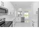 Bright kitchen featuring white cabinets, stainless steel appliances, and modern countertops at 21 N Hampton Ave # Lot 2, Orlando, FL 32803
