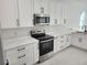 Bright kitchen featuring white cabinets, stainless steel appliances, and modern countertops at 21 N Hampton Ave # Lot 2, Orlando, FL 32803