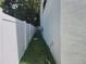 Narrow side yard featuring green grass, white privacy fence, and the home's exterior wall at 21 N Hampton Ave # Lot 2, Orlando, FL 32803