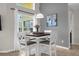 Charming dining nook with a square table, four chairs, and a large window providing ample natural light at 217 Holborn Loop, Davenport, FL 33897