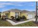 Attractive yellow home with neatly landscaped garden beds and a well-manicured lawn at 217 Holborn Loop, Davenport, FL 33897