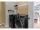 Functional laundry area with appliances, shelving, and convenient access to kitchen at 217 Holborn Loop, Davenport, FL 33897