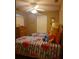 Bedroom showcasing twin beds with floral striped bedding, illuminated by a ceiling fan at 225 Vista Dr, Davenport, FL 33897