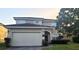 Charming two-story home with brick driveway, well-manicured lawn, and an attached two-car garage at 225 Vista Dr, Davenport, FL 33897