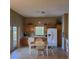 Charming kitchen with wood cabinets, white appliances, eat-in breakfast table, and tile flooring at 225 Vista Dr, Davenport, FL 33897