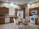 Bright kitchen with oak cabinets, white appliances, tile floors, and a cozy breakfast nook at 225 Vista Dr, Davenport, FL 33897