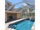A screened in swimming pool, with clear turquoise water and stone trim at 225 Vista Dr, Davenport, FL 33897