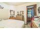 Bedroom with a bed, dresser, mirror, and doorway to another room at 24089 Ne 152Nd Ln, Fort Mc Coy, FL 32134