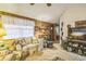 Inviting living room with wood paneling, a ceiling fan, and a comfortable sofa at 24089 Ne 152Nd Ln, Fort Mc Coy, FL 32134