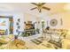 Bright living room with a ceiling fan, TV, and a comfortable sofa with decorative pillows at 24089 Ne 152Nd Ln, Fort Mc Coy, FL 32134