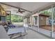 Wide screened-in patio with fan, outdoor furniture, and a view of backyard at 24089 Ne 152Nd Ln, Fort Mc Coy, FL 32134