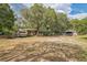 Large lot featuring a single-story home, RV, and outbuildings under a canopy of mature trees at 24089 Ne 152Nd Ln, Fort Mc Coy, FL 32134