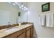 Bright bathroom showcasing a double sink vanity with granite countertops and matching fixtures at 3055 Beach Palm Ave, Kissimmee, FL 34747