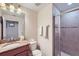 Bathroom featuring tiled shower with glass door and granite countertop sink at 3055 Beach Palm Ave, Kissimmee, FL 34747