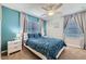 Stylish bedroom with blue accent wall, ceiling fan, and side tables with lamps at 3055 Beach Palm Ave, Kissimmee, FL 34747