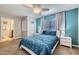 Beautiful bedroom with blue accent wall, ceiling fan and an ensuite bathroom at 3055 Beach Palm Ave, Kissimmee, FL 34747