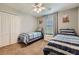 Cozy bedroom featuring twin beds, a ceiling fan, and a closet with ample storage space at 3055 Beach Palm Ave, Kissimmee, FL 34747