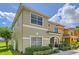 Charming side view of a two-story home featuring lush landscaping and a glimpse of the serene lake at 3055 Beach Palm Ave, Kissimmee, FL 34747