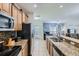 Modern kitchen featuring wood cabinets, granite countertops, stainless steel appliances, and a breakfast bar at 3055 Beach Palm Ave, Kissimmee, FL 34747