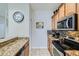 Well-equipped kitchen with granite countertops, wood cabinetry, and stainless steel appliances, adjacent to dining area at 3055 Beach Palm Ave, Kissimmee, FL 34747