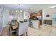 Bright, open-concept living space featuring tile flooring, a spacious dining area, and a breakfast bar at 3055 Beach Palm Ave, Kissimmee, FL 34747