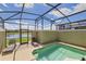 Screened-in pool area with lounge chairs and a view of the lake at 3055 Beach Palm Ave, Kissimmee, FL 34747