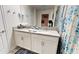Bright bathroom featuring double sinks, granite countertop, and a decorative shower curtain at 3083 Tom Sawyer Dr, Kissimmee, FL 34746