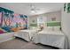 Charming bedroom featuring two cozy beds and playful mural art on the wall at 3083 Tom Sawyer Dr, Kissimmee, FL 34746